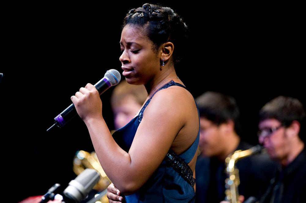 Jazz singer performing on stage with a band.